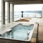 Person maintaining a swim spa by testing water and cleaning surfaces