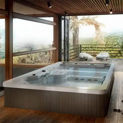 An elegant inground swim spa surrounded by natural stone and tropical landscaping, blending seamlessly with a luxury Florida backyard design.