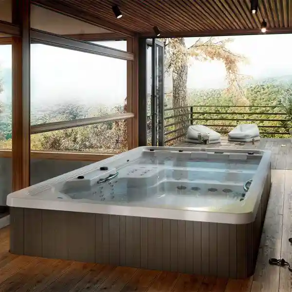 An elegant inground swim spa surrounded by natural stone and tropical landscaping, blending seamlessly with a luxury Florida backyard design.