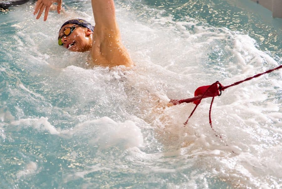 young girl swimming intensively in a swim spa