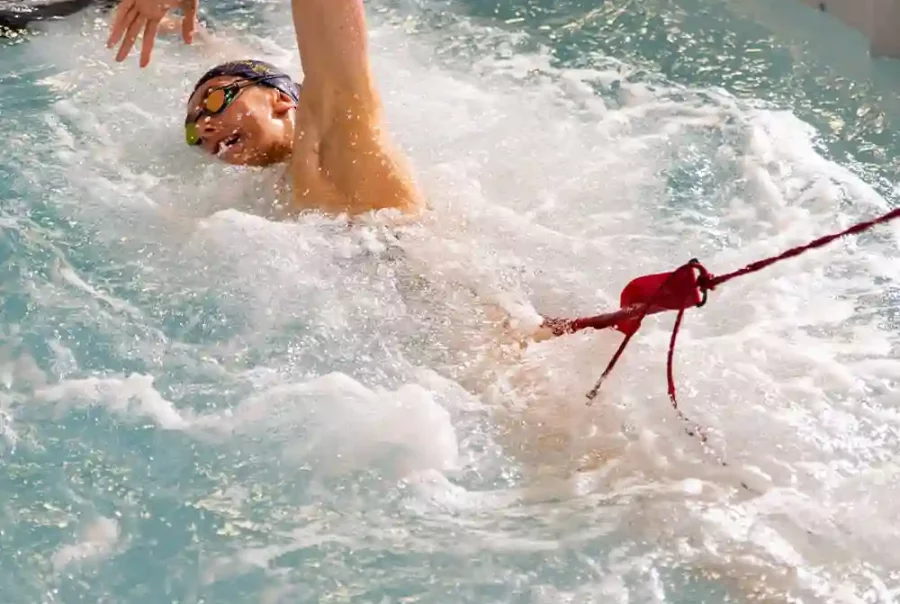 young girl swimming intensively in a swim spa