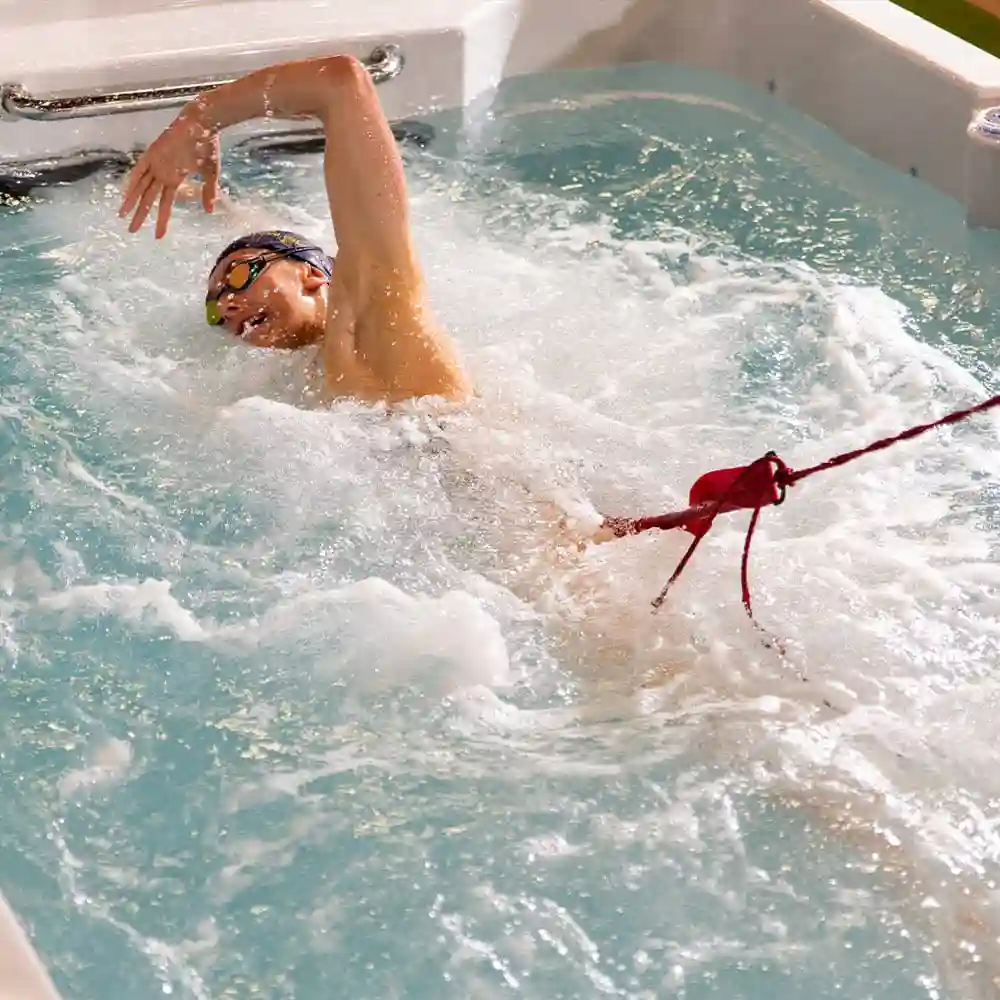 young girl swimming intensively in a swim spa