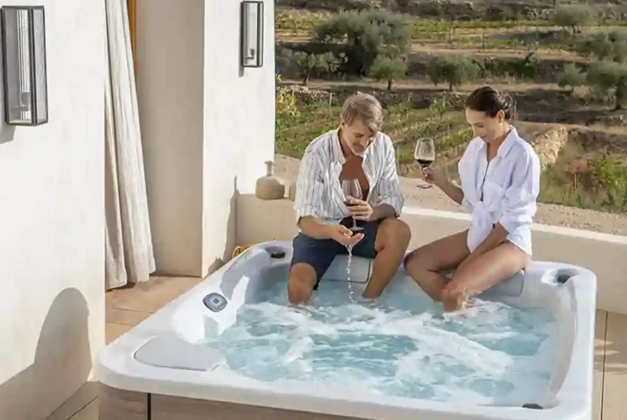 Couple relaxing in an inflatable hot tub on a patio at sunse