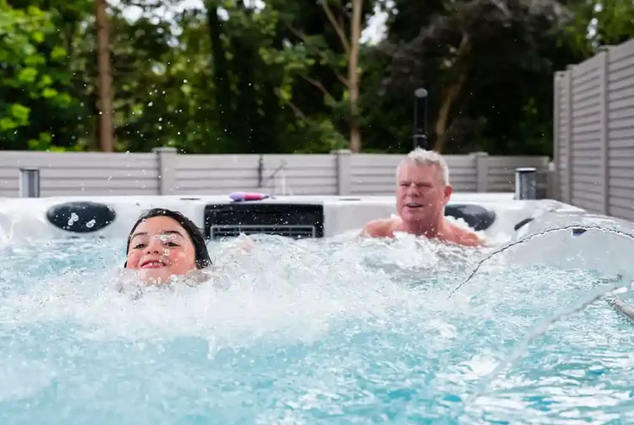 Swim spa with swimmer using resistance current and person relaxing in massage sea