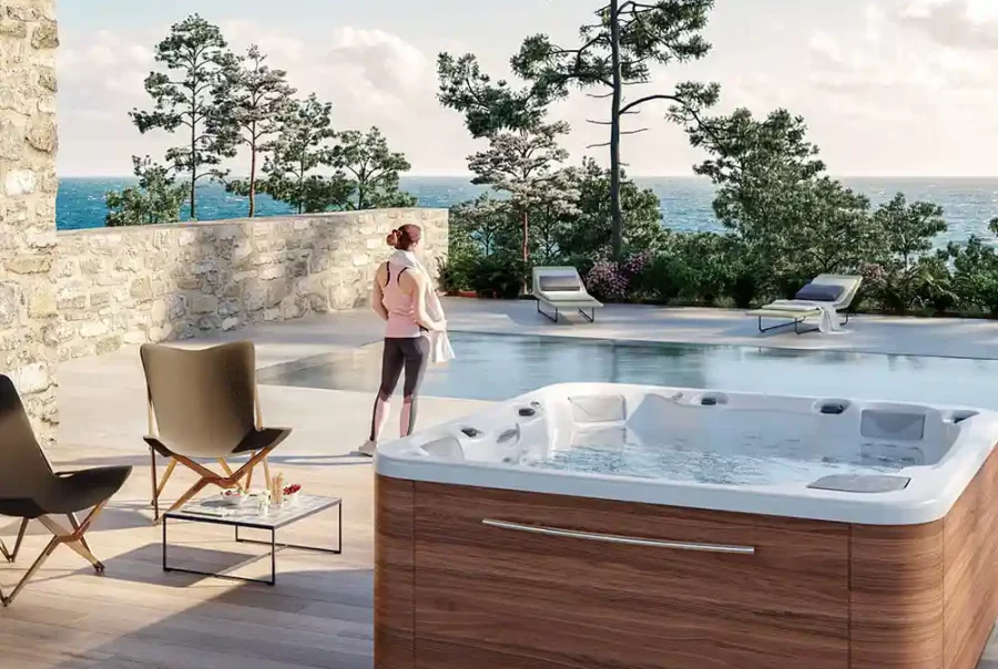 Above ground hot tub installed on a deck with soft lights and greenery