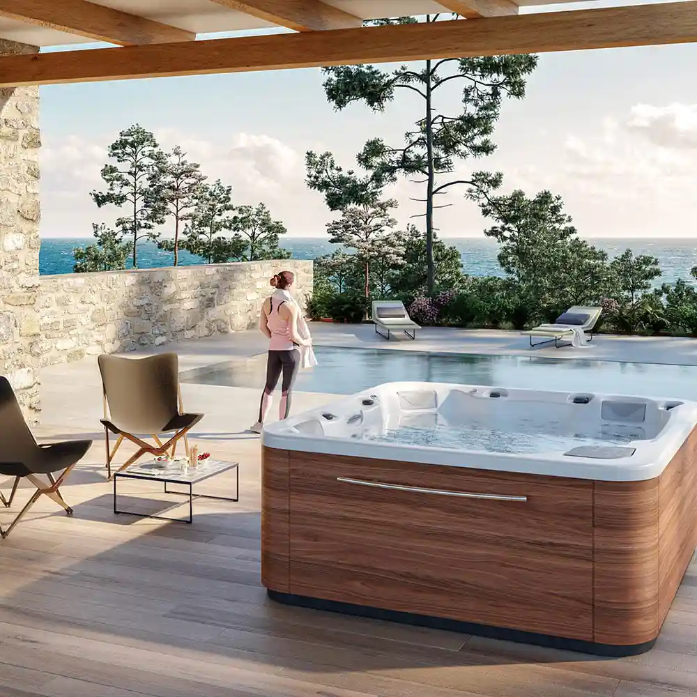 Above ground hot tub installed on a deck with soft lights and greenery