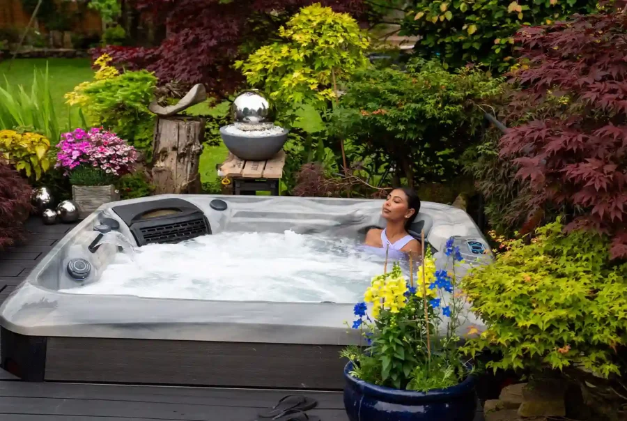 Portable hot tub on backyard deck with steam and ambient lighting