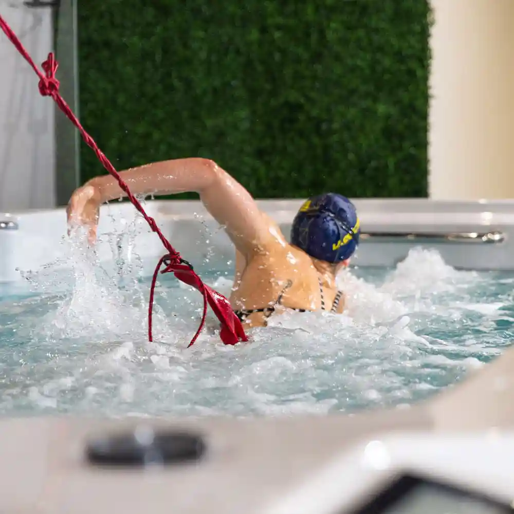 Swimmer training in a swim spa with proper body position and freestyle technique
