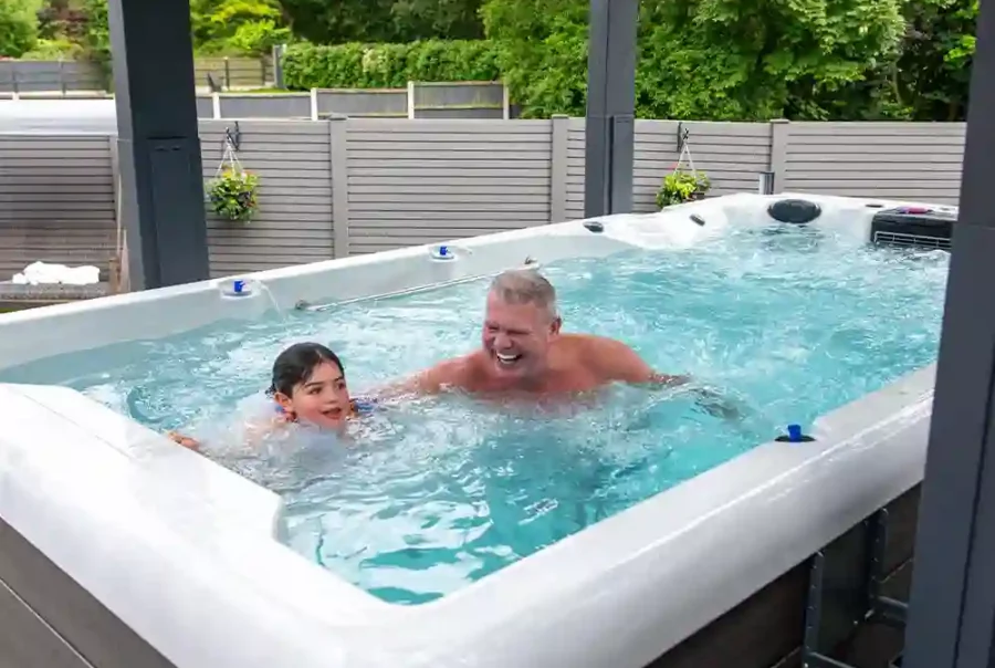 Why buy a swim spa – father and daughter using dual-zone spa for exercise and hydrotherapy in a tropical backyard