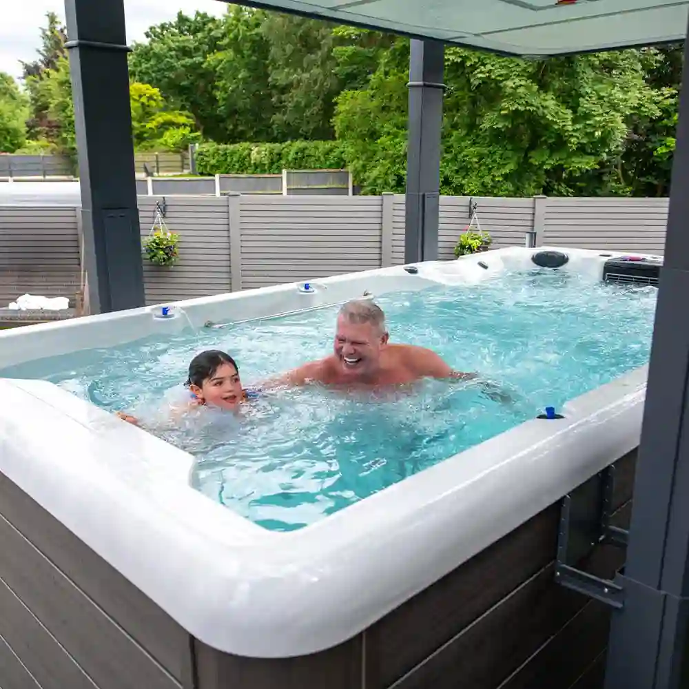 Why buy a swim spa – father and daughter using dual-zone spa for exercise and hydrotherapy in a tropical backyard
